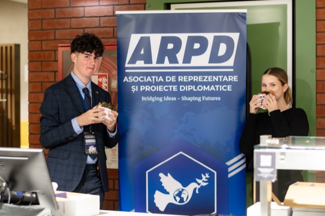 A delegate and an organizer hold burgers on either side of the ARPD banner.