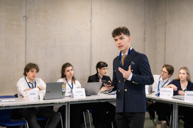 A standing delegate addresses seated country representatives.
