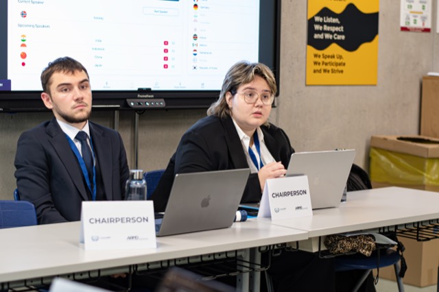 Two chairpersons manage the session from the dais with a speaker list on screen.